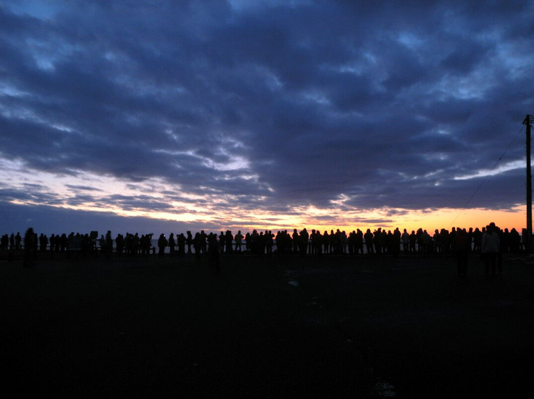 Ferne Silhouetten einer Menschenmenge auf einem Platz in der Abenddämmerung